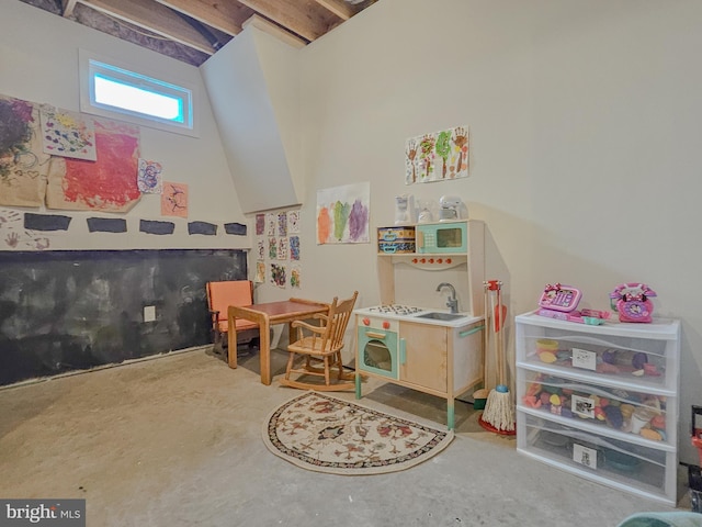 recreation room with unfinished concrete floors and a sink