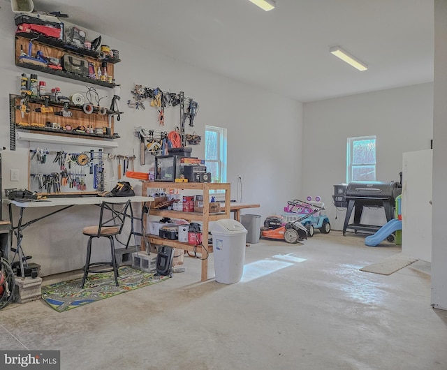 interior space featuring unfinished concrete floors and a workshop area