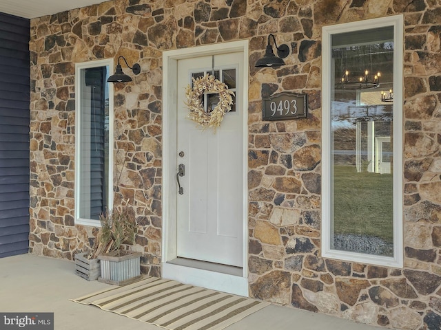 doorway to property featuring stone siding and brick siding