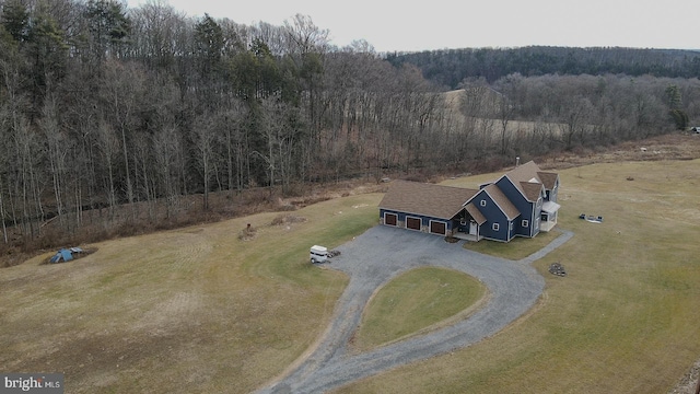 bird's eye view with a wooded view