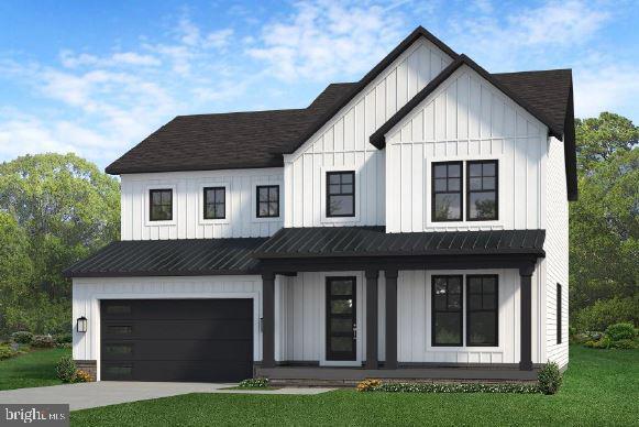 modern farmhouse style home featuring a standing seam roof, concrete driveway, a front lawn, and board and batten siding