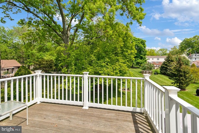 wooden deck featuring a lawn