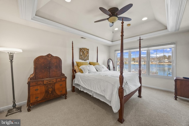 bedroom featuring carpet floors, crown molding, a raised ceiling, visible vents, and baseboards