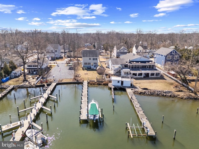 view of dock featuring a water view, boat lift, and a residential view