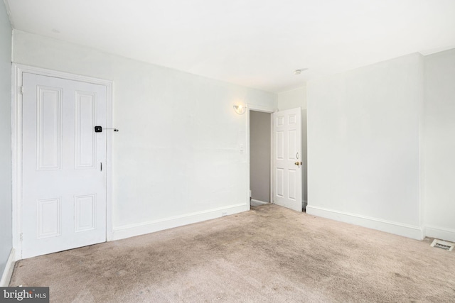 carpeted empty room featuring visible vents and baseboards