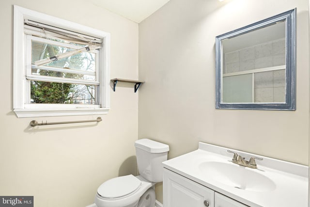 bathroom with vanity, toilet, and baseboards