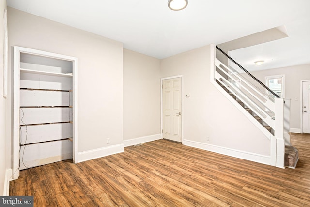 interior space with stairway, wood finished floors, and baseboards