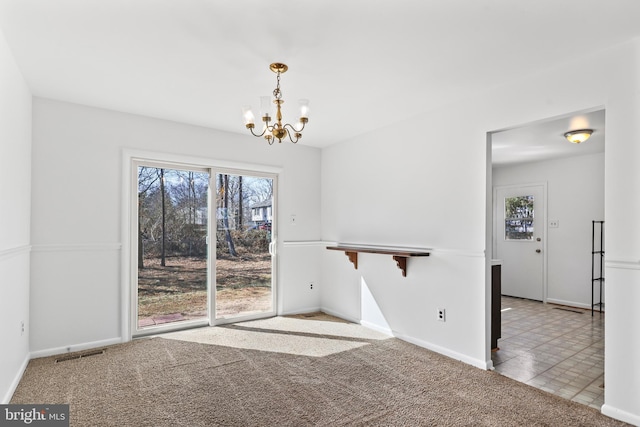 unfurnished dining area featuring light colored carpet, visible vents, light tile patterned flooring, a chandelier, and baseboards