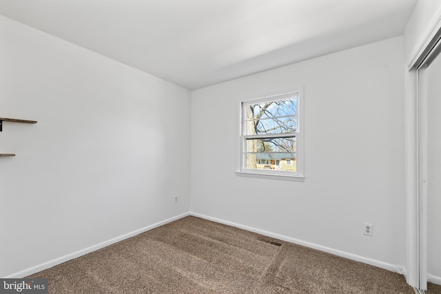 unfurnished bedroom with a closet, carpet, visible vents, and baseboards