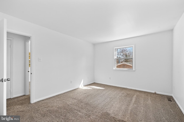 spare room featuring carpet floors and baseboards