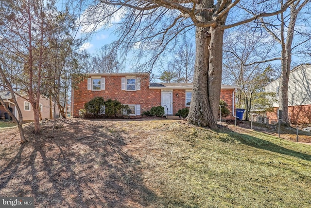 split level home with brick siding and a front lawn