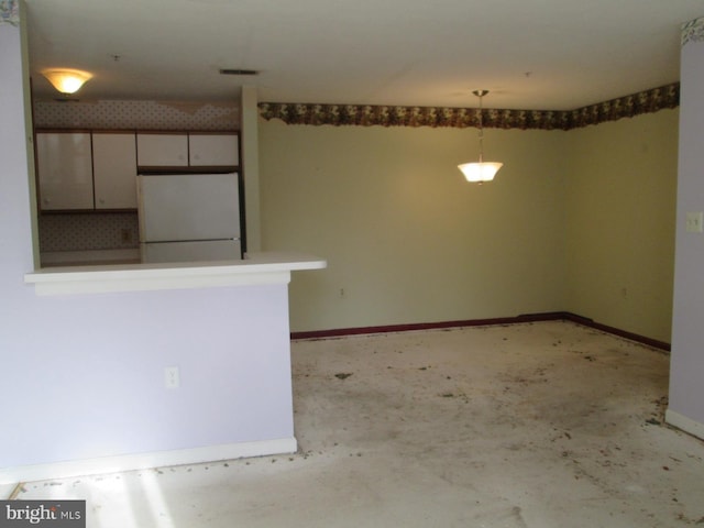 unfurnished room featuring baseboards and concrete floors
