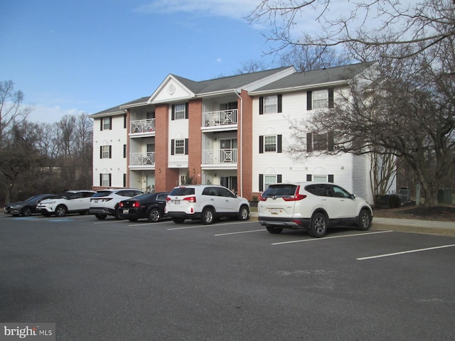view of apartment building / complex with uncovered parking