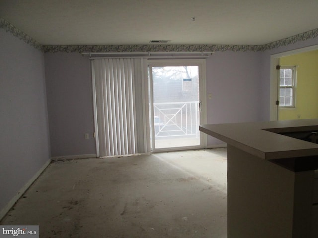 unfurnished room featuring plenty of natural light and baseboards