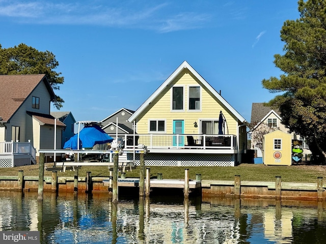 rear view of property with a lawn and a deck with water view