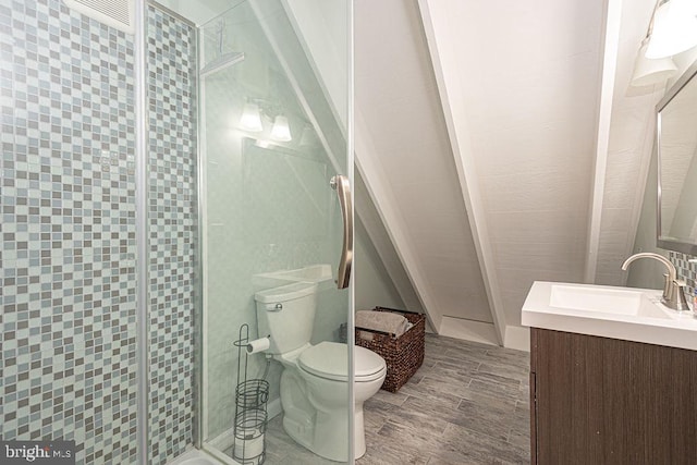 bathroom featuring wood finish floors, a stall shower, vanity, and toilet