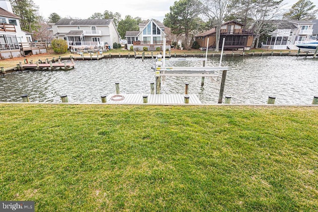 view of dock featuring a water view, boat lift, a residential view, and a yard