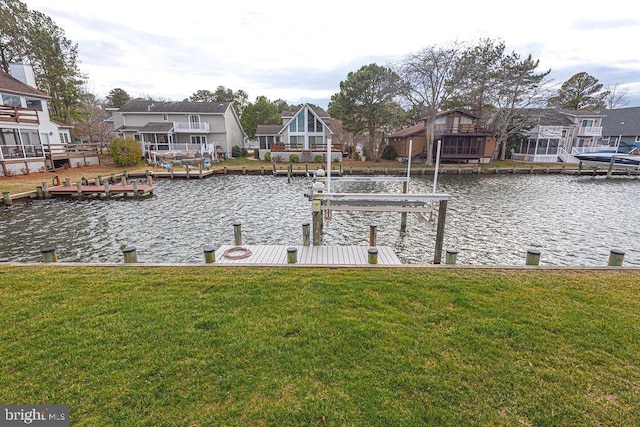 view of dock featuring a residential view, a water view, and a lawn