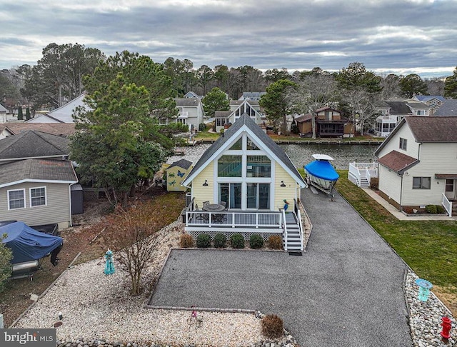 view of front of property featuring covered porch, aphalt driveway, and a residential view