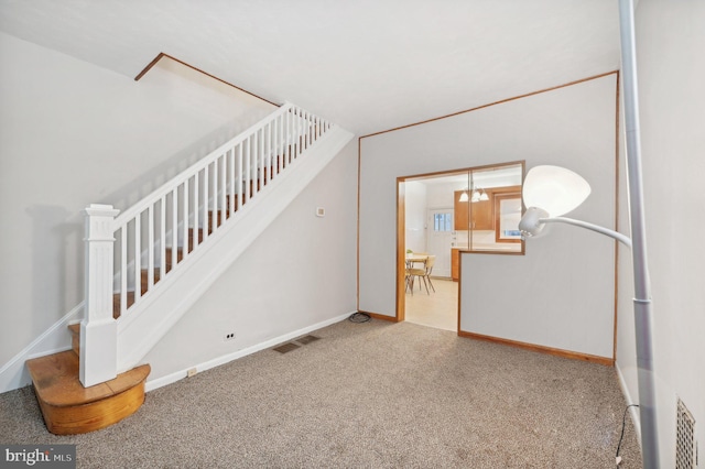 staircase featuring carpet flooring, visible vents, baseboards, and an inviting chandelier