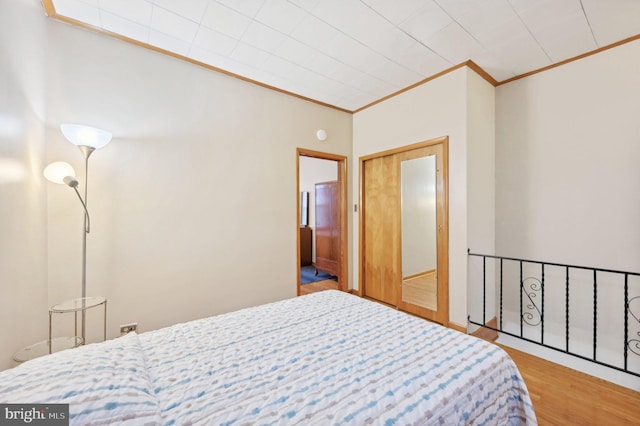 bedroom featuring crown molding and wood finished floors