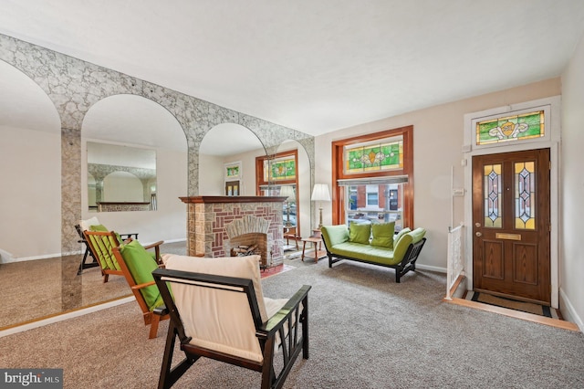 living room with carpet, a fireplace with flush hearth, and baseboards