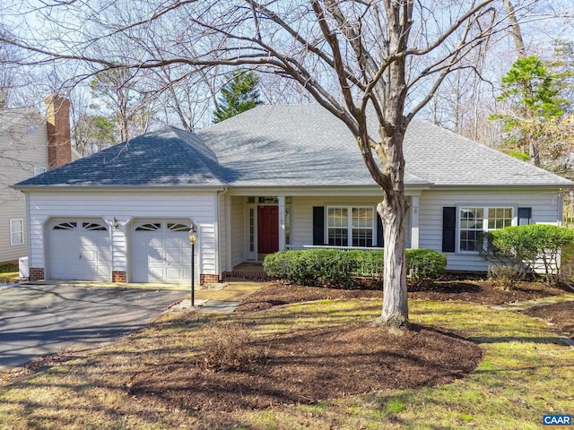 ranch-style house with a garage, roof with shingles, and aphalt driveway