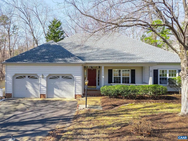 ranch-style home featuring roof with shingles, driveway, and an attached garage