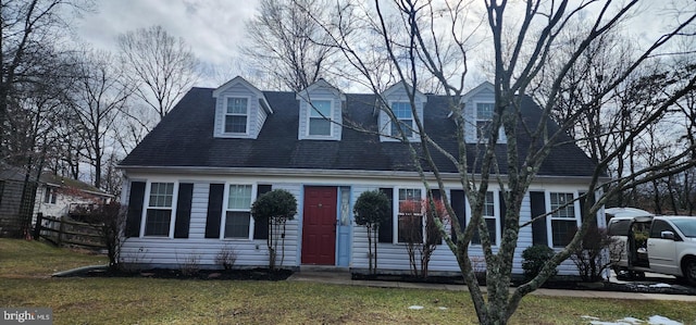 new england style home featuring fence and a front lawn