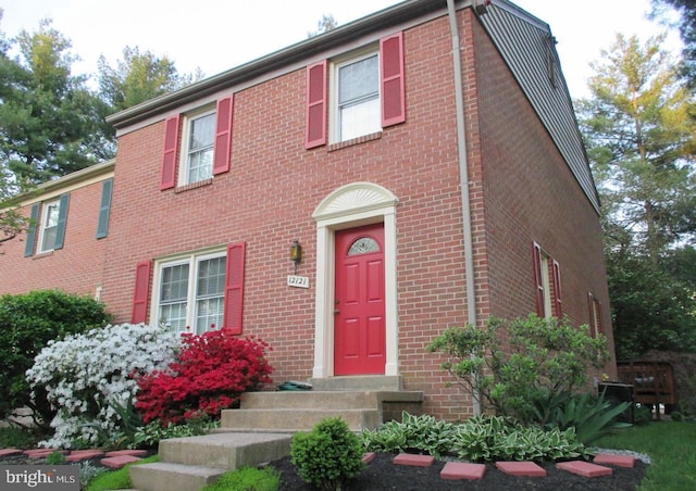 colonial house featuring brick siding