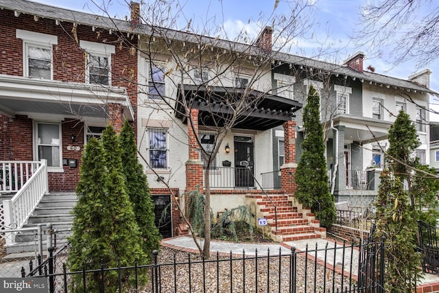 view of front of property featuring a fenced front yard and brick siding