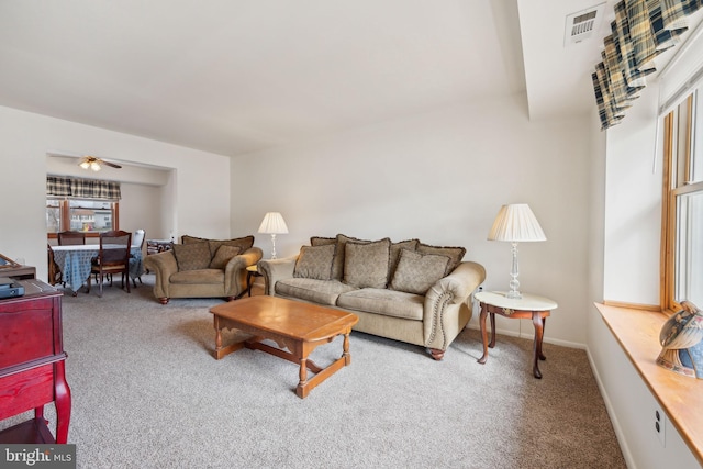 living room with carpet, visible vents, ceiling fan, and baseboards