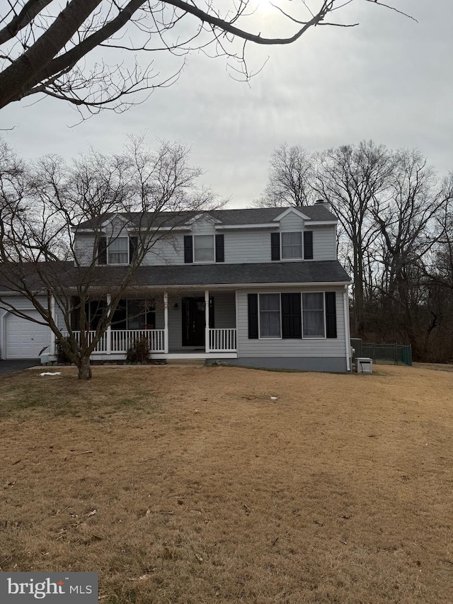 view of front of house with a porch, roof with shingles, and a front yard