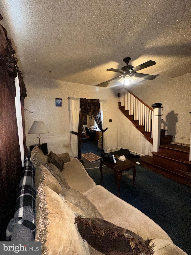 living room featuring a ceiling fan, stairway, and a textured ceiling