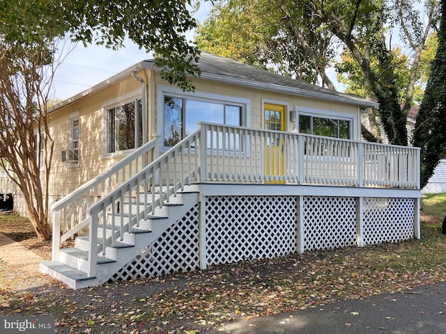 rear view of property featuring stairway and a deck