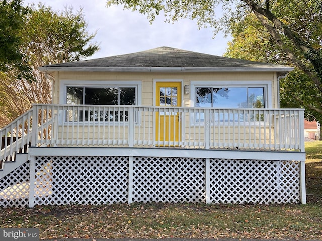 back of property with stairway, a shingled roof, and a deck