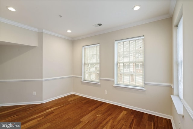 unfurnished room featuring visible vents, crown molding, baseboards, and wood finished floors