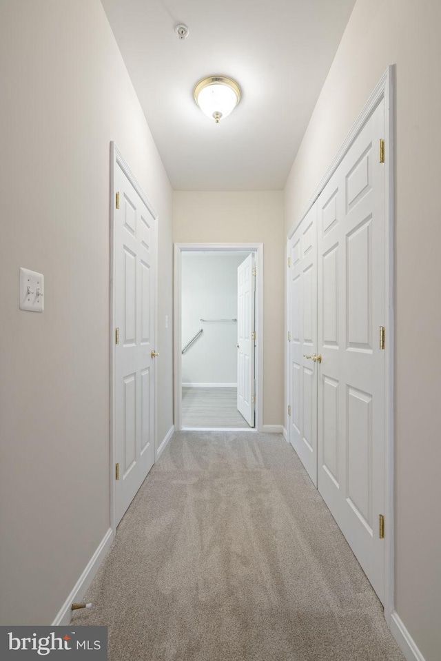 hallway featuring carpet floors and baseboards