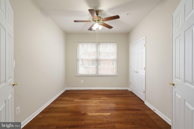 interior space with wood finished floors, a ceiling fan, and baseboards