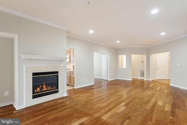 unfurnished living room featuring light wood finished floors, baseboards, visible vents, and a tiled fireplace