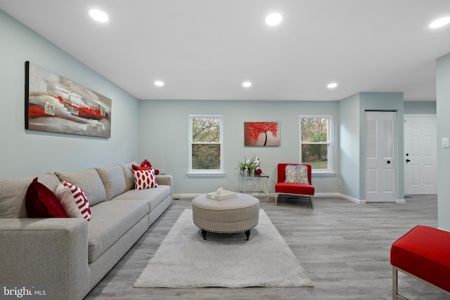 living room with light wood finished floors and recessed lighting