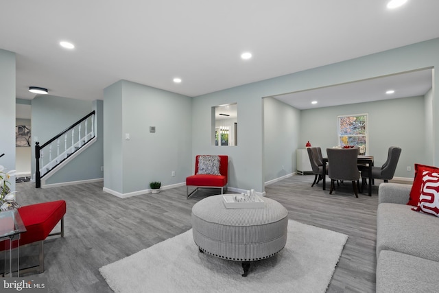 living room with light wood-style floors, recessed lighting, stairway, and baseboards