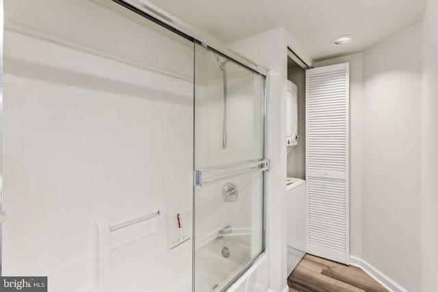 full bathroom with bath / shower combo with glass door, wood finished floors, and baseboards