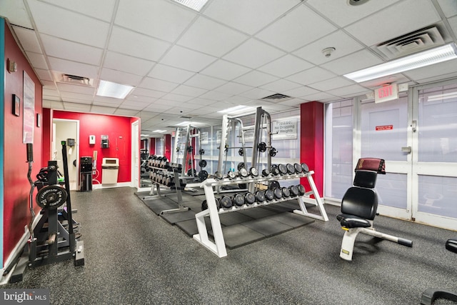 gym with a paneled ceiling and visible vents