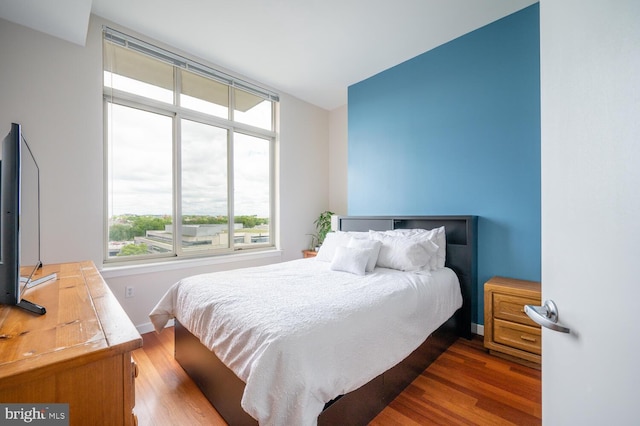 bedroom with baseboards and dark wood-style flooring