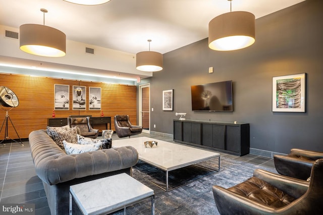 living area featuring baseboards and visible vents