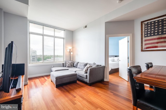 living room with baseboards, visible vents, and light wood-style floors