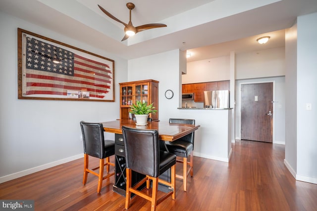 dining room with dark wood-type flooring, baseboards, and a ceiling fan
