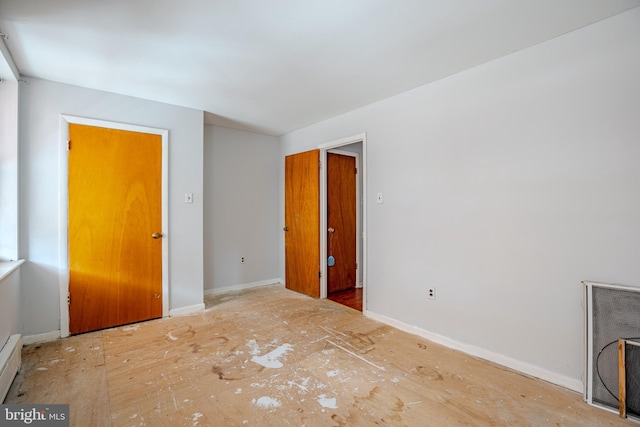 unfurnished bedroom featuring baseboard heating and baseboards