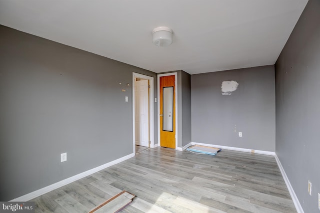 empty room with light wood-style flooring and baseboards